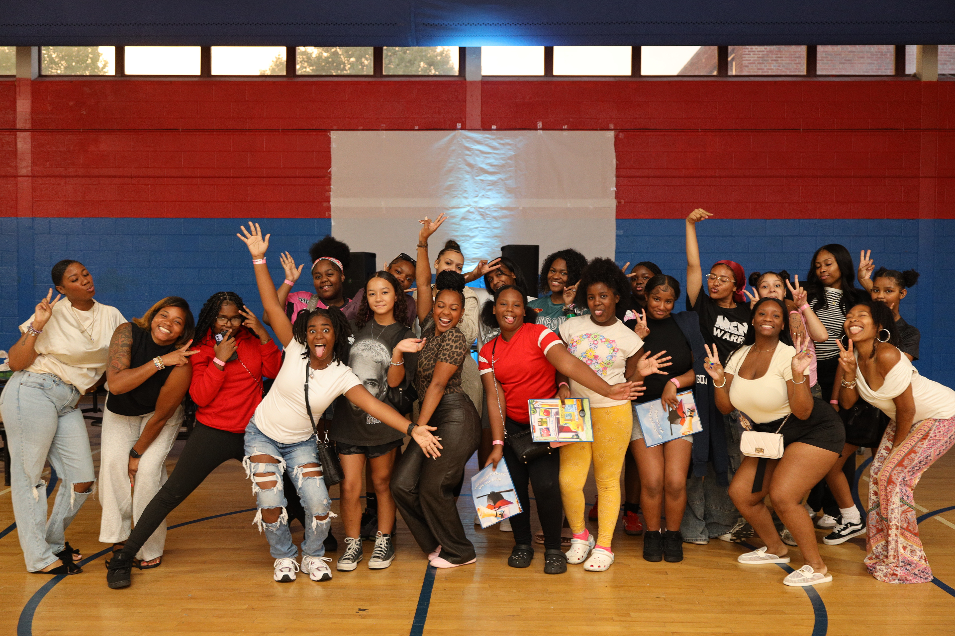 Lynda, founder of I AM N.I.T.A, surrounded by smiling mentees outdoors